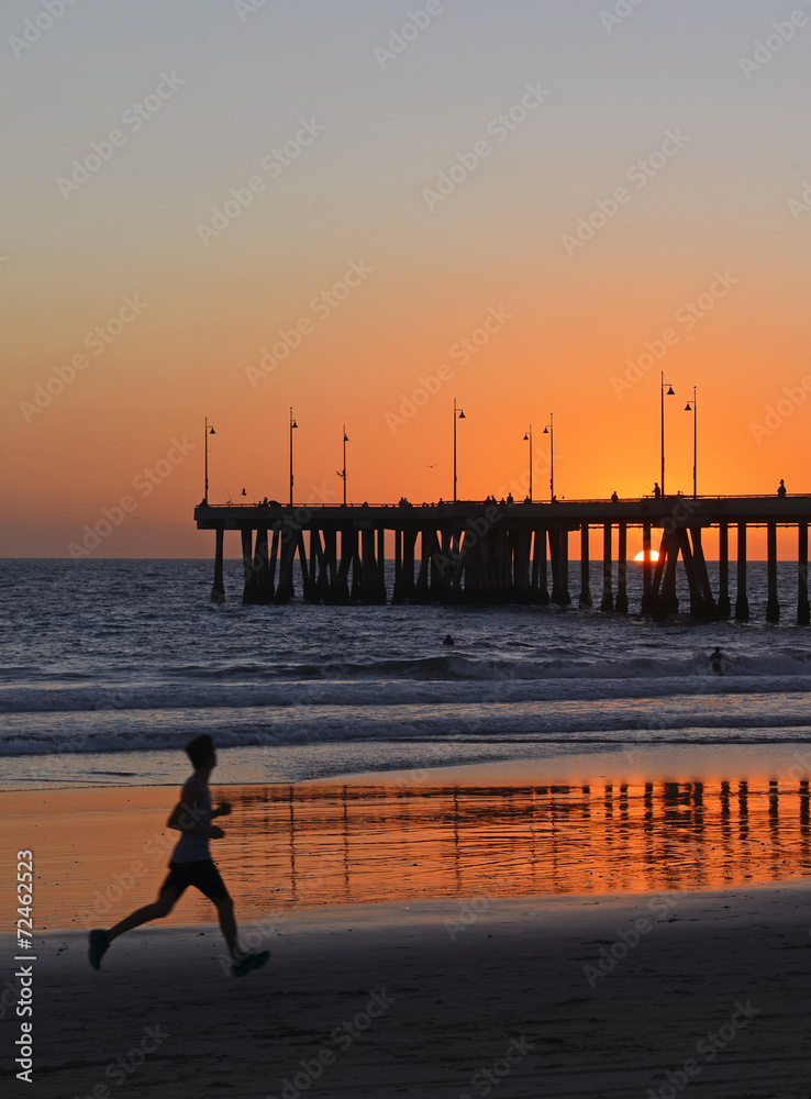 Obraz premium Silhouette of Jogger Running on beach at Sunset, California
