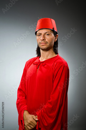 Funny man in red dress wearing fez hat