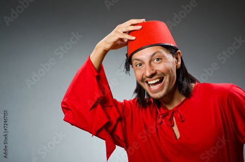 Funny man in red dress wearing fez hat photo