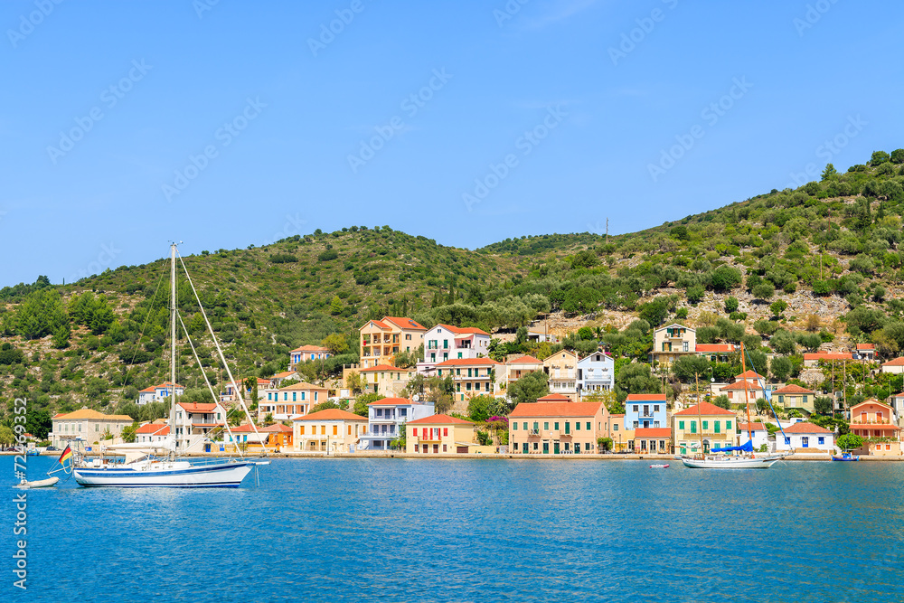 Yacht on sea and colorful houses of Vathi town, Ithaka island