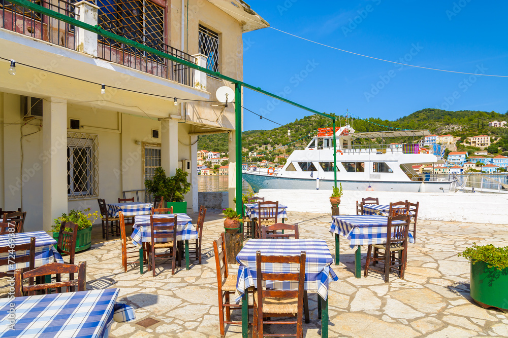 Fototapeta premium Krzesła i stoły w greckiej restauracji, port Vathi, wyspa Itaka