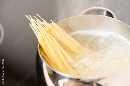 Pan with spaghetti cooking in boiling water