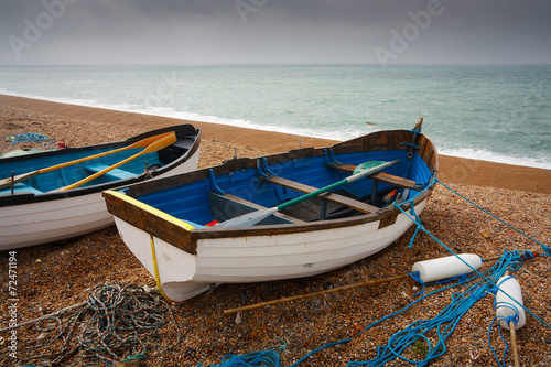 Fishing boats and equipment on Chesil Beach in Dorset, UK.