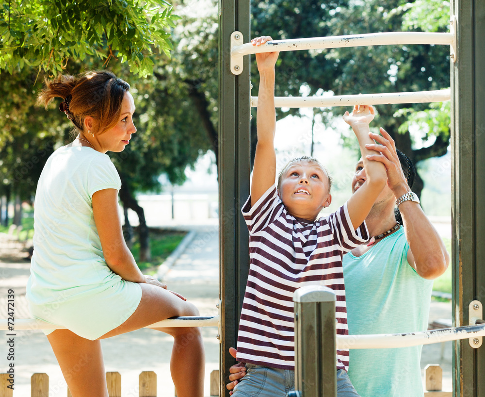 Obraz premium couple with son training with chin-up bar