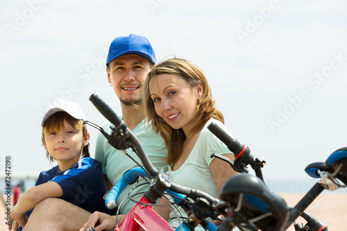 Family with bicycles on beach