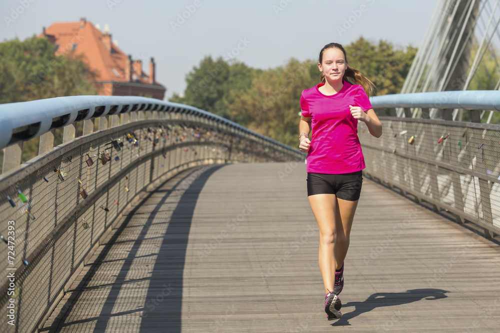 Running girl. Young girl runner on the bridge.