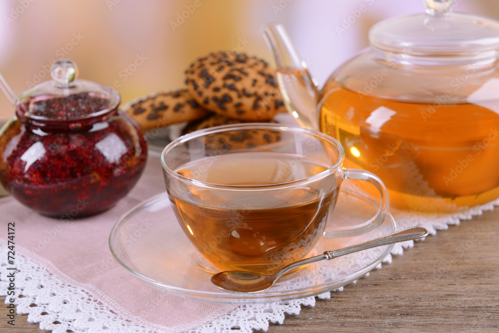 Teapot and cup of tea on table on light background Teapot and cup of tea on table on light background