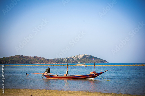 Boats on sand beach overlooking island