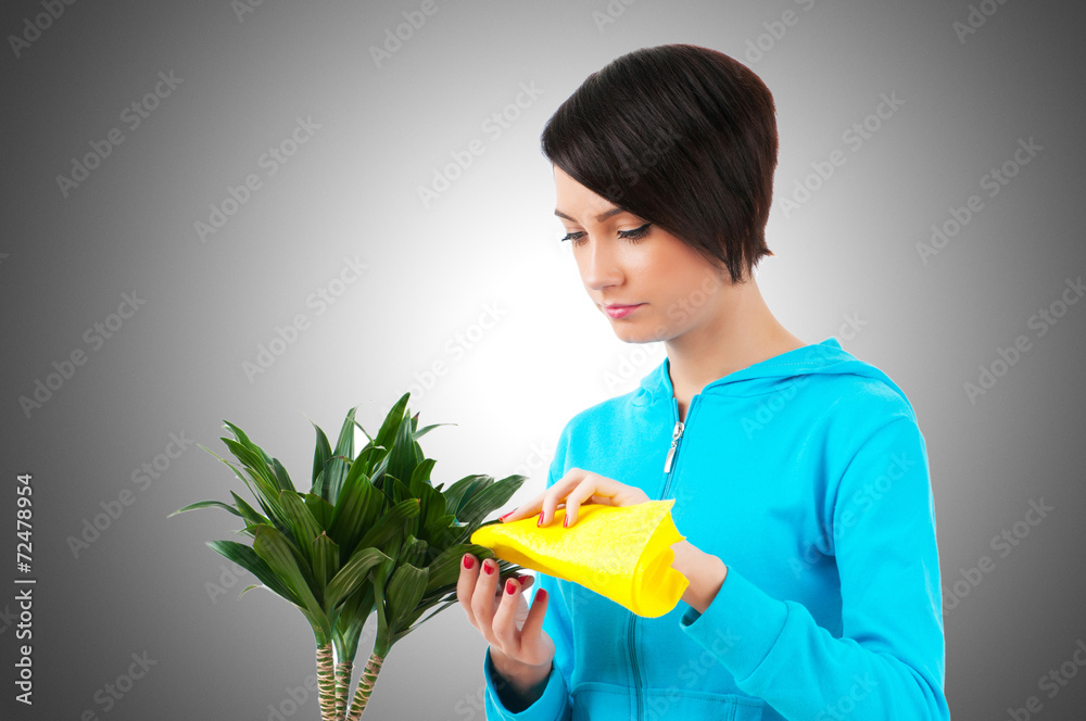 Young woman watering plants isolated on white Young woman watering plants isolated on white