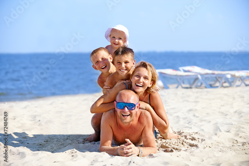 Mother and father with three children on the beach.