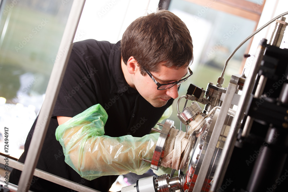Fotografie Scientist inserts hand laser deposition chamber