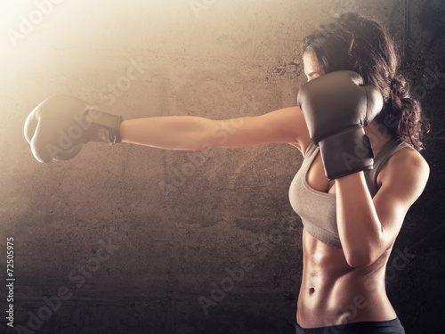 Fitness woman punching with boxing gloves