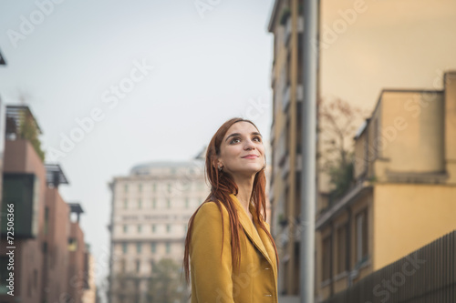 Redhead girl posing in the city streets