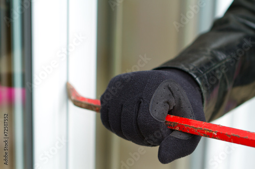 Foto Burglar breaking in a house
