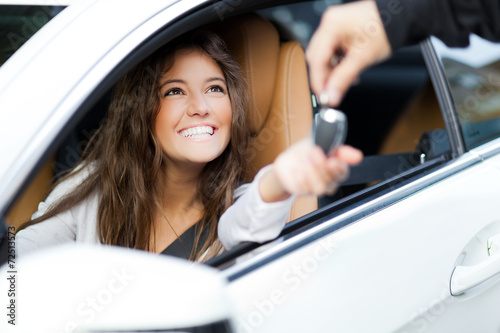 Woman receiving keys of her new car from dealer