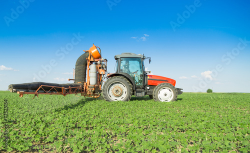 Farmer in tractor spraying soybeans