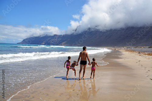 familia caminando por la playa de famara en lanzarote