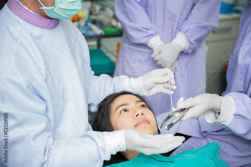 Dentist curing a asian female patient