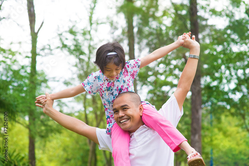 Asian Muslim father and daughter piggyback