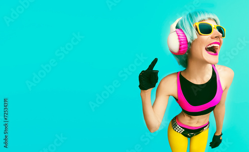 Glamorous fashion dj girl in bright clothes on a blue background photo