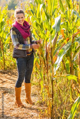 Fototapeta Full length portrait of happy young woman in cornfield
