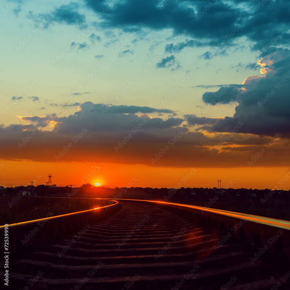 Fototapeta premium low sun over railroad to horizon in sunset