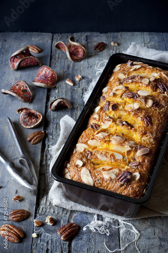 orange plumcake with pecan walnuts on mold with nutcracker