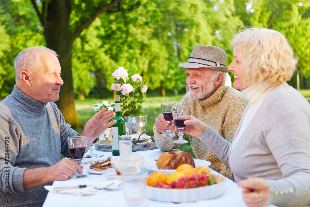 Alte Freunde beim Kaffeetrinken im Garten StockFoto Adobe Stock