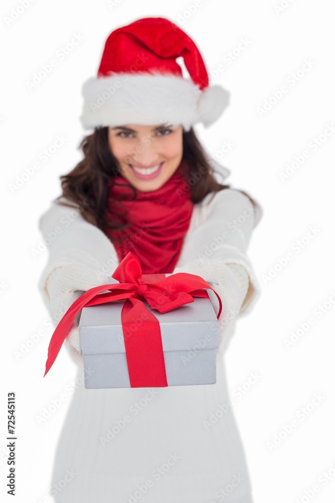 Festive brunette in santa hat giving gift Festive brunette in santa hat giving gift