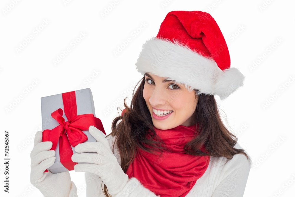 Excited brunette in santa hat showing gift Excited brunette in santa hat showing gift