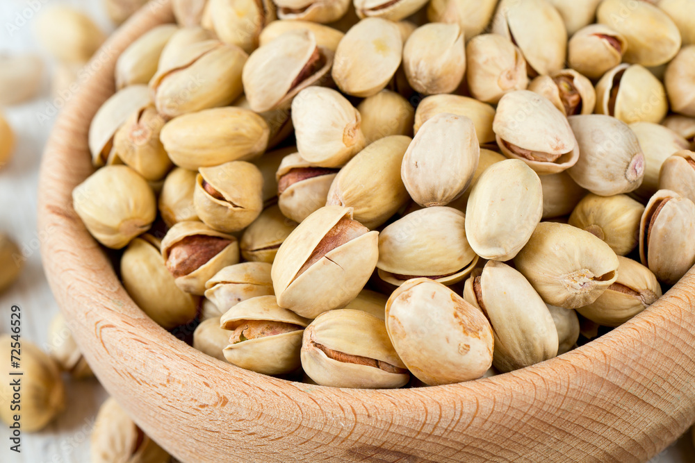 full bowl of pistachio on wooden surface full bowl of pistachio on wooden surface