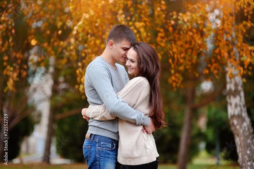 Man and woman embracing in autumn park