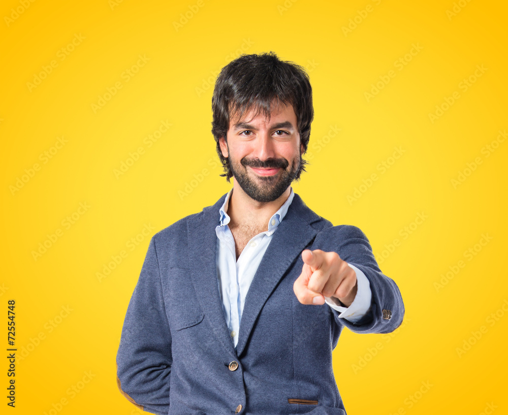 Man pointing to the front over yellow background Man pointing to the front over yellow background