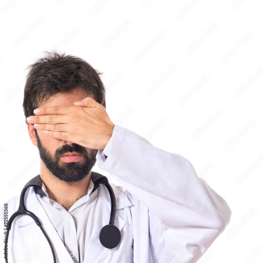 Doctor covering his eyes over isolated white background Doctor covering his eyes over isolated white background