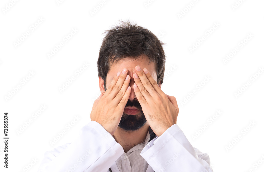 Doctor covering his eyes over isolated white background Doctor covering his eyes over isolated white background