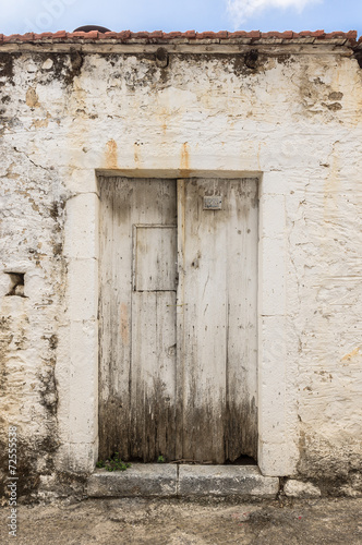 Old white timber door in the scuffed wall
