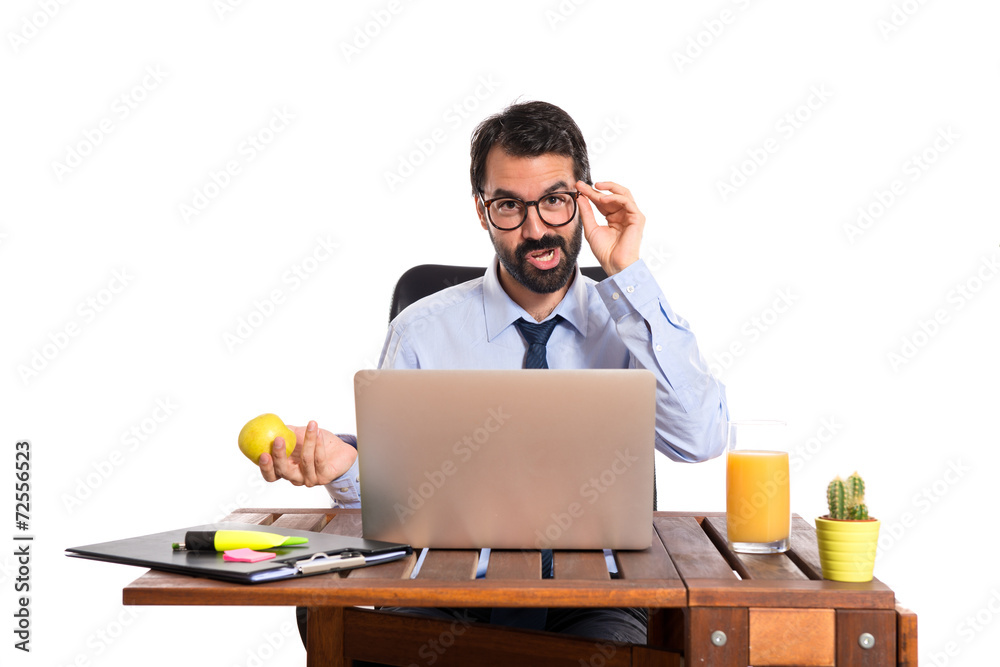 Businessman in his office holding an apple Businessman in his office holding an apple