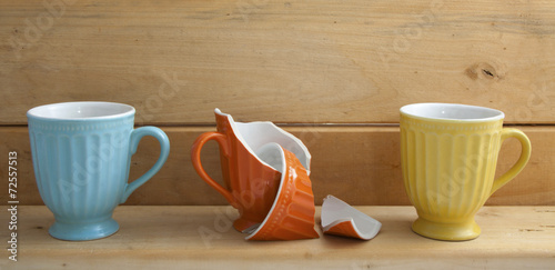 Three cups on wooden shelf