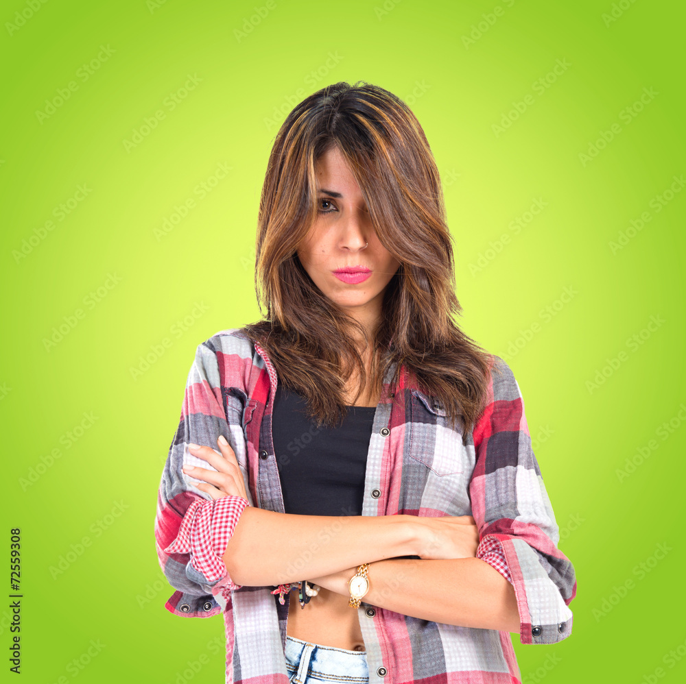 Girl with her arms crossed over green background Girl with her arms crossed over green background