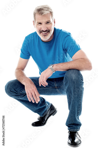 Handsome man crouching down and smiling