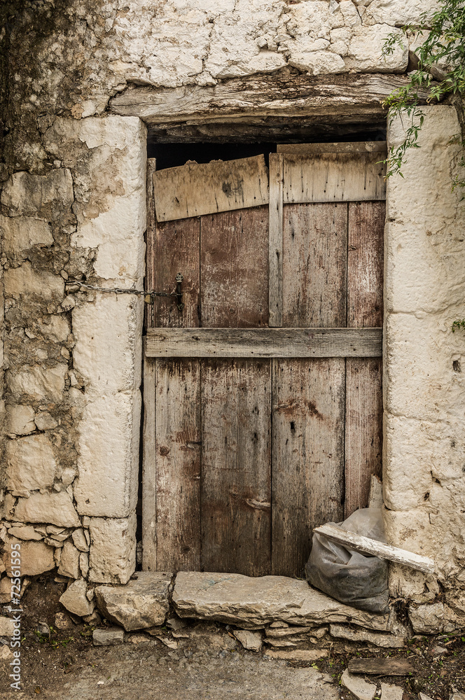 Old timber door in the scuffed wall Old timber door in the scuffed wall