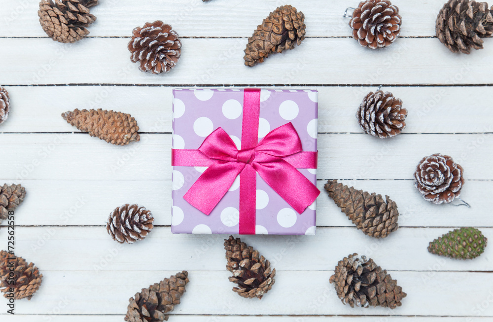 Gift box and and pine cone on a wooden table. Gift box and and pine cone on a wooden table.