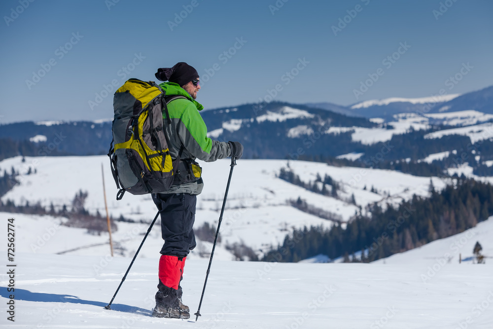 Hiker in winter mountains on sunny day