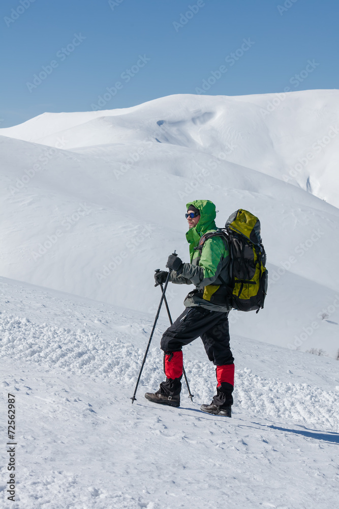 Hiker in winter mountains on sunny day Hiker in winter mountains on sunny day