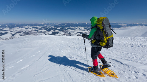 Hiker snowshoeing in winter mountains during sunny day © Maygutyak