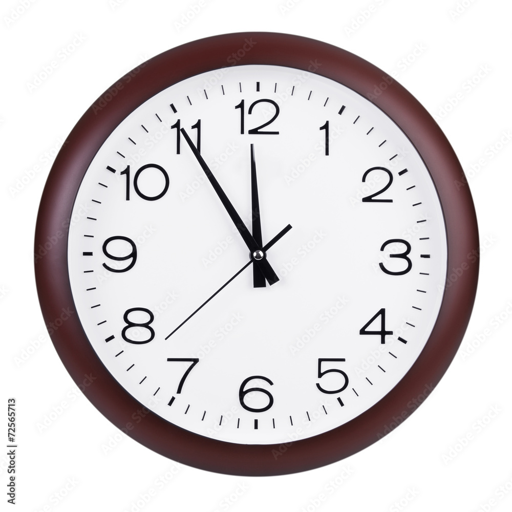 Round clock shows five minutes to twelve Round clock shows five minutes to twelve