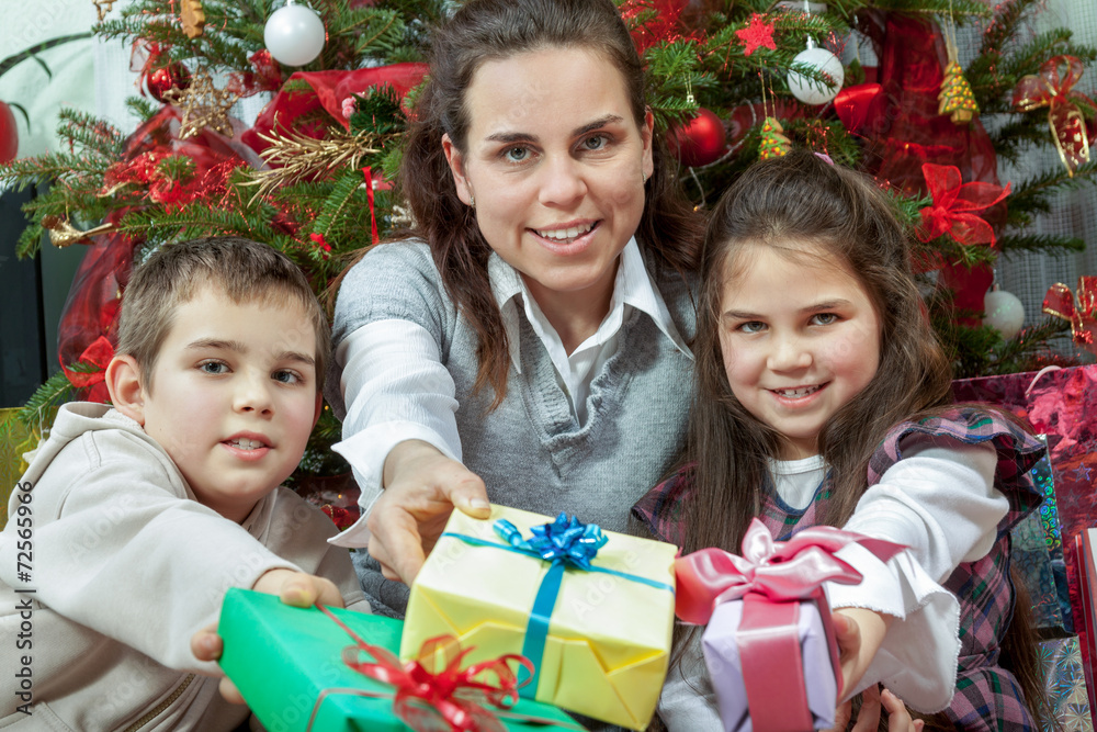 Family exchanging gifts in front of Christmas tree Family exchanging gifts in front of Christmas tree