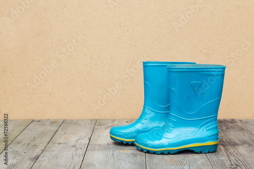 Blue rubber boots on a wooden floor © annakukhmar