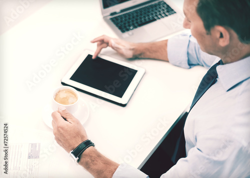 businessman with tablet pc and coffee in office