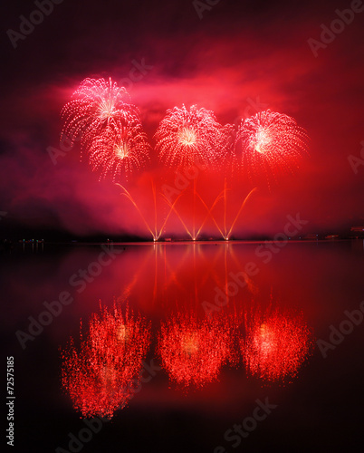 Beautiful red fireworks reflecting in water